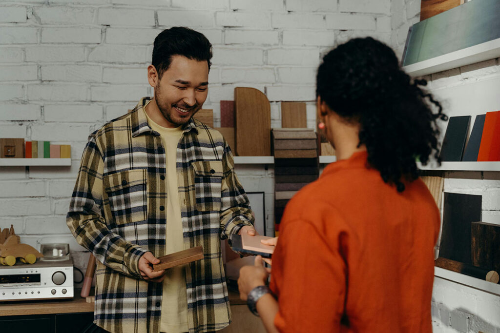Smiling Salesman Showing Wood Samples to a Client